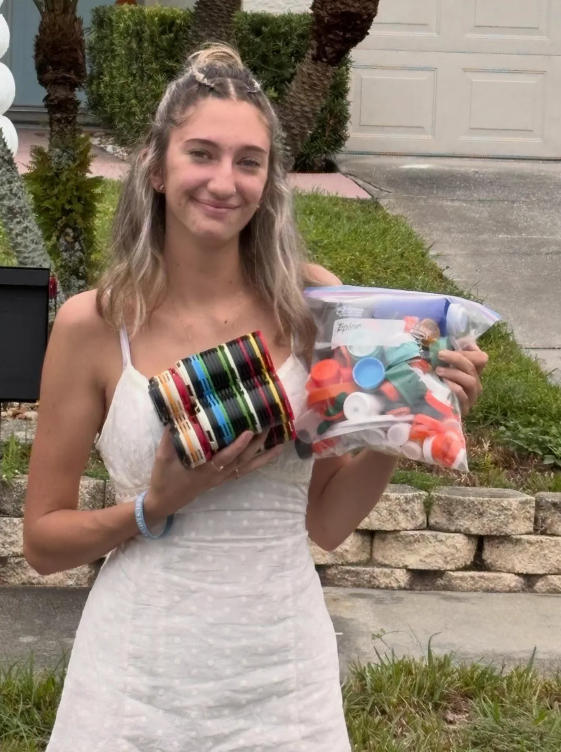 Marissa holding collected plastic caps